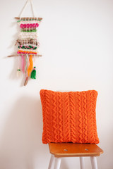 Оранжевая вязаная подушка в интерьере