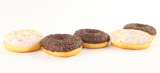 Five sweet white and chocolate donuts are on white table