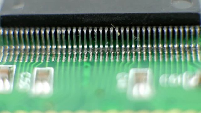 Electonic components microchips or cpu leg contacts. Integrated semiconductor microchip. Microprocessor on green circuit board. System board with microchips and transistors