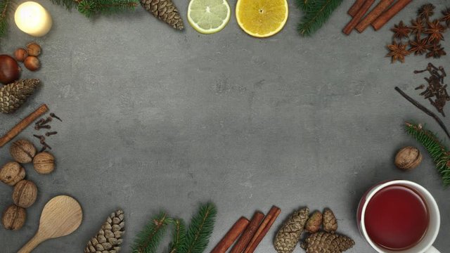 Top view on spices and natural winter decorations arranged around border. Christmas time concept. Stop motion animation.