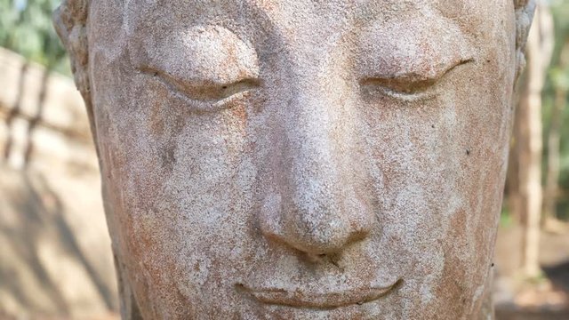 4K footage. Calm and peaceful face of old worship buddha statue head illuminated. Buddha statue at Chiangmai history temple. Chiang Mai Province, Thailand , Asia
