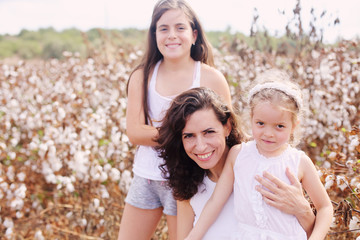 Fototapeta na wymiar Portrait of beautiful mother with two daughters outdoors