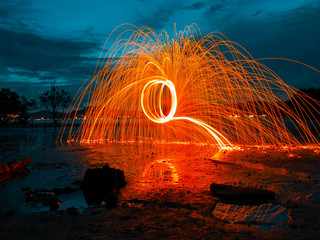 light lines of steel wool with long exposure, speed motion abstract background in the dark night
