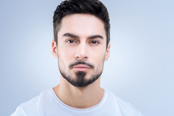 Fototapeta premium Smart man. Responsible clever handsome student looking calm and ready for passing his exams while being at the university
