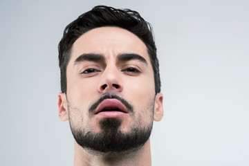 Obraz premium Sensual. Young handsome man with black beard looking emotional and passionate while standing calmly and waiting for his girlfriend