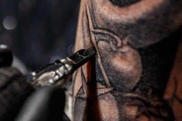 Artist tattooing of man's skin