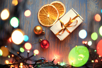 Christmas gift box and illumination decorations on wooden background copy space for lettering top view