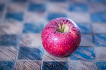 Apfel auf kariertem Holzuntergrund
