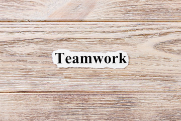 Teamwork of the word on paper. concept. Words of Teamwork on a wooden background