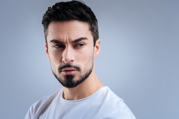 Fototapeta premium Rational person. Clever talented professional scientist frowning and looking concentrated while waiting for his colleagues and thinking about his plans for the day