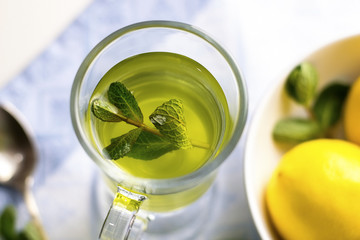 Mint Tea. Herbal tea. Mint leaf and lemon tea in a glass cup. Dried tea, sliced lime. herbs tea and mint leaves  in a restaurant or teahouse tea room.
