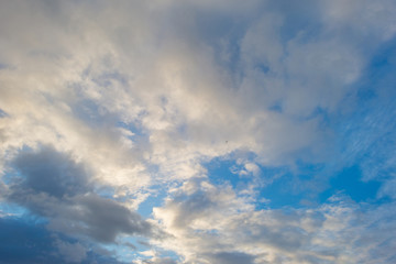 Naklejka na ściany i meble Clouds in a blue sky in sunlight at fall