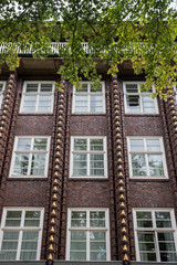 Facade of red brick Building with golden Ornaments and white Windows, Hamburg, Germany, Europe