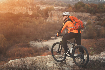Traveler with backpack Riding the Bike on the Beautiful Spring Mountain Trail