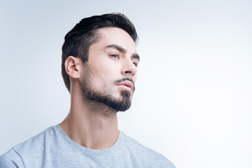 Fototapeta premium Arrogant person. Serious strict arrogant person showing no interest in communicating with other people while standing alone and looking thoughtful