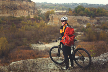 Traveler with backpack Riding the Bike on the Beautiful Spring Mountain Trail