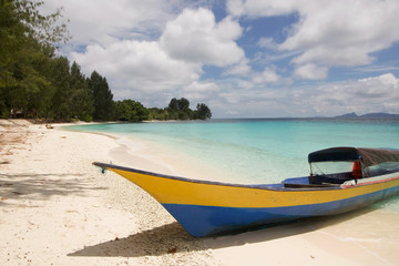 part of a small boat berthed on a tropical beach in raja ampat archipelago