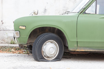 Obraz na płótnie Canvas Broken old car at the side of a Greek road