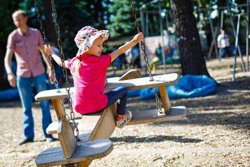 A cute young girl riding airplane swing