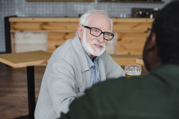 senior friends talking and drinking beer