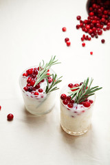 Perfect christmas cocktail: coconut margarita with cranberries and rosemary. Minimalistic concept. Linen cloth and white background. Vertical composition with copy space.