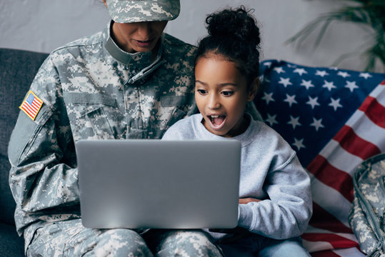 soldier and child using laptop