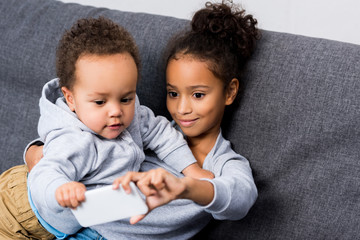 sister taking selfie with little brother