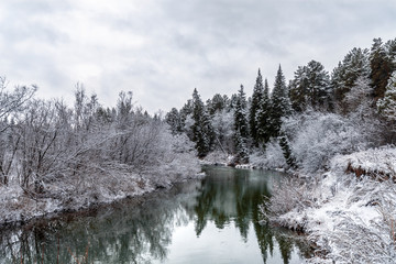A cooling river with the first snow on the shore