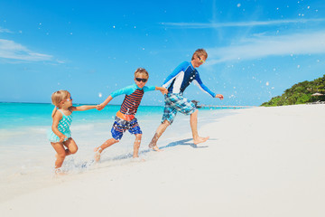 Fototapeta na wymiar father with kids play with water run on beach
