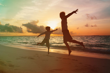 father and little son enjoy sunset beach