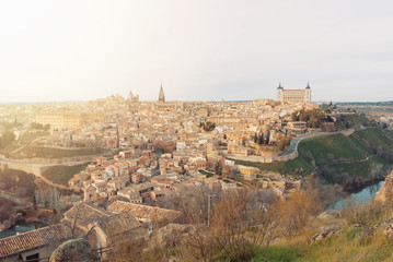 An evening view to Toledo old town and Cathedral in the sunlight from a viewpoint over the hill at surroundings of the town, Castilla La Mancha, Spain.