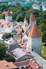 Aerial panoramic view of Tallinn old town city center towers and walls and narrow medieval streets on cloudy day, Estonia.