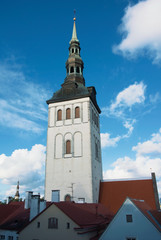 Saint Nicholas Church over red tiled roofs at Tallinn, Estonia in the evening.