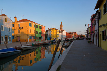 Fototapeta na wymiar Colorful houses and boats at sunset in Burano, Venice Italy.