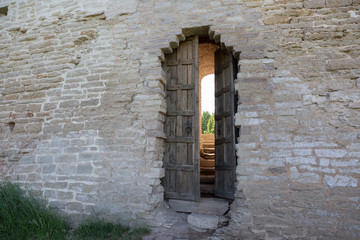 Fototapeta premium Old wooden door in a stone wall