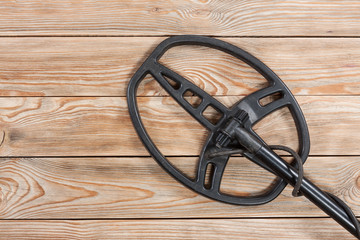 Metal detector on old rustic wooden table.