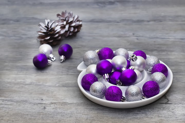 Silver and purple decorative balls on a gray background. Concept of the Christmas and new year.