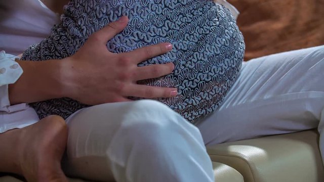 A young woman is sitting on her boyfriend's lap and he is passionately grabbing her booty.
