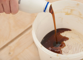 The man mixes the two components of the glue