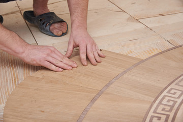 The carpenter installs one of the decorative elements of the parquet.