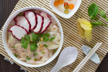 Shrimp Wonton and Pork red roasted in white bowl on bamboo grille and  wooden table