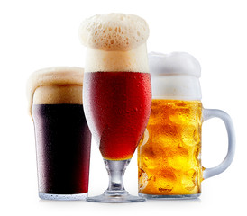 Mug collection of frosty dark red and light beer with foam isolated on a white background