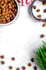 dry dog food in bowl on stone background top view