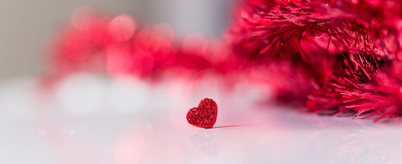 alla hjärtans dag banner med ett rött glitter hjärta på vitt med glitter ofokuserat i bakgrunden