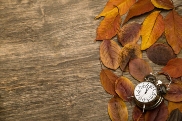 Old clock on a background of yellow leaves