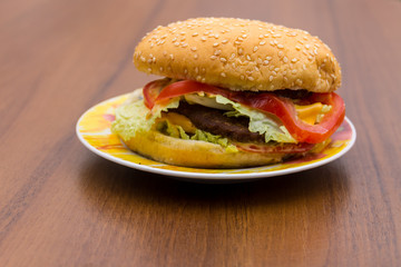 Delicious hamburger or sandwich on plate on wooden table
