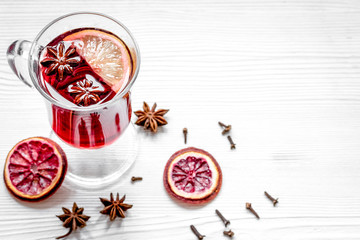 mulled wine with spices in cup on wooden background