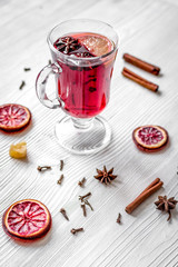 mulled wine with spices in cup on wooden background