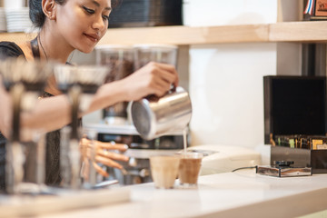 Beautiful thai female barista making coffee