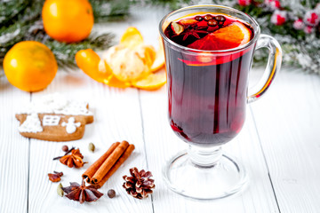 Christmas mulled wine with spices in cup on wooden background